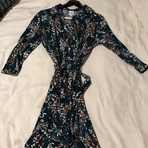 Knee length green dress with tied waist. Button down top. Floral design.